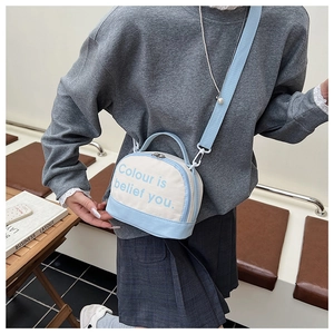 Detail of blue and white canvas crossbody bag featuring metal zippers and wide strap