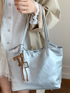 Metallic silver large tote bag with brown leather charm accessory for daily casual use