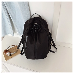 Detailed view of black nylon outdoor backpack with side buckles and Guanlin logo