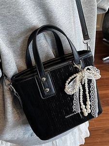 Chic black bucket bag with vertical textured PU leather and a pearl lace bow charm