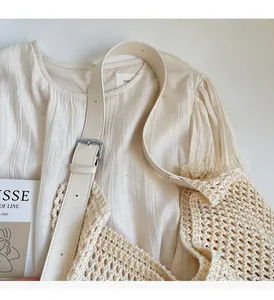 Detail showing the hollow knit pattern and beige leather strap with a metal buckle