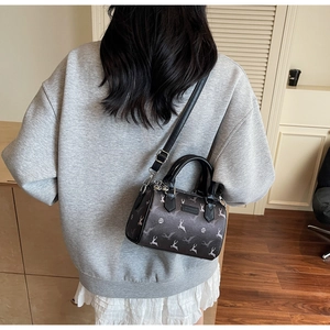 Sac Boston foncé avec motifs d'élans blancs porté par un mannequin dans un salon