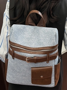 Blue denim texture backpack with brown leather straps and decorative buckle design