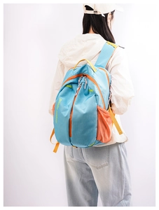 Rear view of model wearing a sky blue outdoor backpack with orange zippers and yellow straps