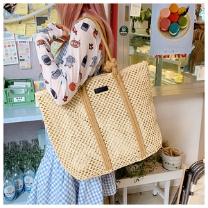 Detail showing the beige hollow mesh weave and brown rope handle of a large tote bag