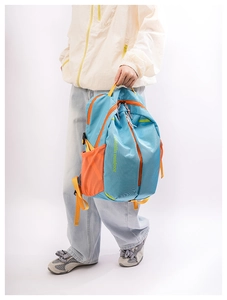 Detail view of large capacity blue and orange backpack with mesh side pocket