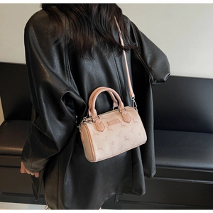 Détail du sac Boston rose cylindrique avec motifs de cerf et ferrures argentées