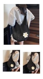 Detail of black crochet shoulder bag featuring a 3D white daisy floral applique