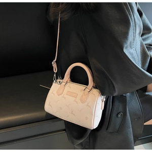 Détail d'un mini sac Boston rose avec motif de cerf et finitions argentées sur un mannequin
