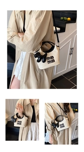 Detailed close-up of straw bucket bag with leather handles and min min logo