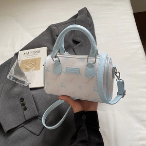 Détail du mini sac Boston avec imprimé élan bleu et une bandoulière réglable amovible