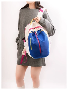 Close-up of color-block backpack showing zip compartments and mesh side pocket detail