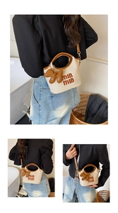Detail of woven straw handbag with brown leather straps and puppy charm on model