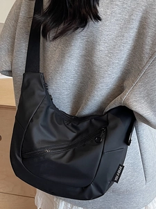 Minimalist black nylon dumpling crossbody bag with adjustable strap and front zipper pocket