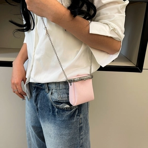 Detailed side view of pink pebbled leather mini lipstick bag with silver chain strap
