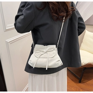 Cremeweiße Schleifen-Schultertasche am Modell für stilvolles Sommer-Styling