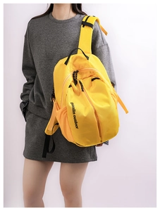 Detail view of bright yellow durable nylon backpack with zip pockets and mesh side bags