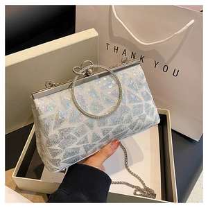 Dettaglio della pochette da sera con paillettes, motivo geometrico e manico ad anello