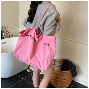 Detail of pink canvas tote bag with black San Francisco text print and rope handle