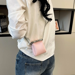 Chic pink leather mini bag with silver kiss-lock clasp and chain strap on a model