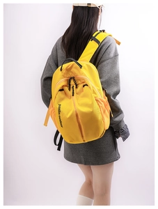 Close-up of lightweight bright yellow nylon outdoor backpack with side mesh pocket