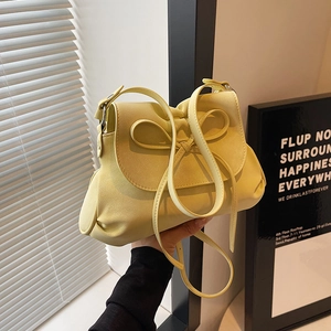 Detail of the pale yellow ballet style bow on a PU leather shoulder bag with adjustable strap