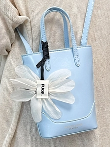 Minimalist light blue mini tote bag with flower charm and crossbody strap for women