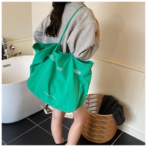 Detail of green canvas tote bag with San Francisco text shown in a bright bathroom