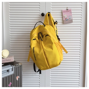 Detail view of bright yellow outdoor backpack with side mesh pocket and multiple zippers