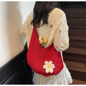 Detail of red hollow knit shoulder bag with a white 3D crochet flower decoration