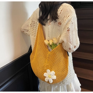 Detail of yellow handmade crochet shoulder bag featuring a 3D white flower and woven texture