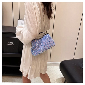Chic sequined evening bag with silver chain strap worn with a white dress