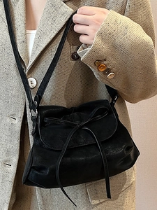 Minimalist black ballet style bow shoulder bag with sleek matte finish and slim straps