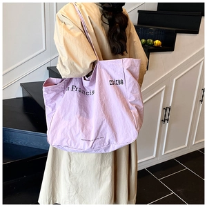 Close-up of lightweight lavender tote bag with recycled fabric texture and printed text