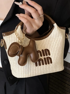 Minimalist straw basket tote bag with brown leather trim and cute puppy charm