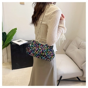 Detail shot of multicolor sequin evening bag with silver chain strap on model