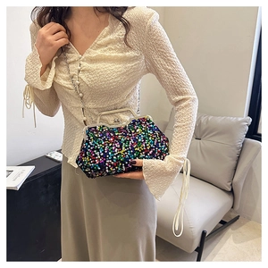 Detail of sequin evening bag featuring pearl chain strap and silver metal clasp frame