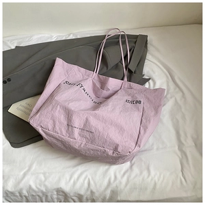 Detail of light purple recyclable tote bag featuring artistic typography and eco-friendly text