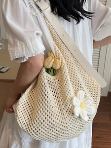 Chic off-white crochet shoulder bag featuring large knit flower and leather strap