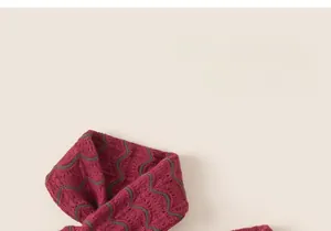 Dettaglio di sciarpa lavorata a maglia per bambini con motivi a onde rosa scuro e grigio-verde
