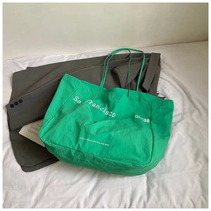 Detail of green tote bag with white San Francisco print and long shoulder straps