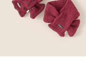 Piatto di sciarpa in maglia bordeaux spessa e guanti con motivo a onde su sfondo beige