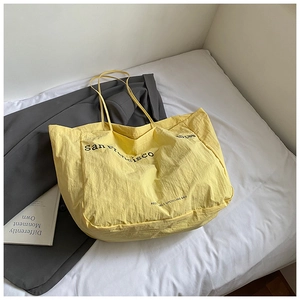 Detail of a yellow tote bag with San Francisco print on a white minimal lifestyle background