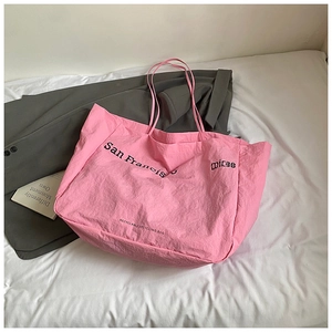 Close-up of pink textured tote bag featuring San Francisco graphic print on white fabric