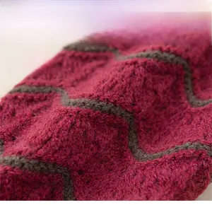 Dettaglio di sciarpa in maglia invernale con strisce ondulate rosse e grigie e lana