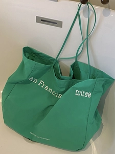 Eco-friendly bright green large tote bag with San Francis print on a white bathtub
