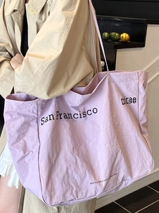 Minimalist light purple tote bag with San Francisco print shown on a model's shoulder