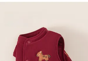 Détail du gilet en polaire rouge pour enfant avec écusson cheval et bouton pression