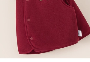 Gros plan sur le tissu polaire bordeaux doux avec boutons et coutures de précision soignées