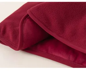 Détail du gilet en polaire rouge pour enfant montrant le tissu chaud et l'ourlet